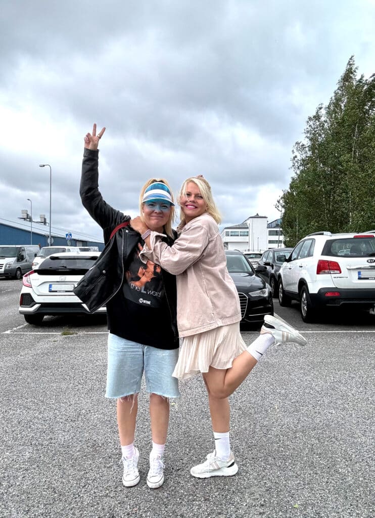 Susanna ja Ella Rosti hymyilemässä halauksessa parkkipaikalla. 